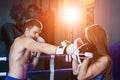 Male and female sporty couple practicing boxing at the gym at boxing ring.