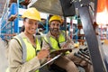 Male and female staff discussing over clipboard in warehouse