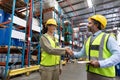 Male and female staff shaking hands with each other in warehouse Royalty Free Stock Photo