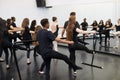 Male And Female Students At Performing Arts School Rehearsing Ballet In Dance Studio Using Barre