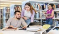 Male and female students preparing for exam together in library Royalty Free Stock Photo