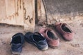 Male and female students take off their shoes at the front entrance of an abandoned cottage.