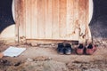 Male and female students take off their shoes at the front entrance of an abandoned cottage.