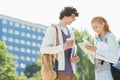 Male and female students using digital tablet at college campus Royalty Free Stock Photo