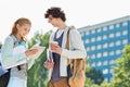 Male and female students using digital tablet at college campus Royalty Free Stock Photo