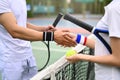 Male and female tennis players shaking hands over net at tennis court after the match. Good sportsmanship, friendship Royalty Free Stock Photo