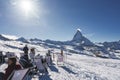 Tourist relaxing on deck chairs on snowy landscape at ski resort