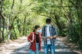 Male and female tourists wear medical masks and look at the map on the street