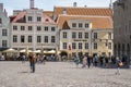 Male and female travelers exploring market in city square at historic town