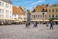 Male and female travelers exploring market in city square at old historic town