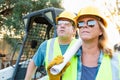 Male and Female Workers With Technical Blueprints at Construction Site Royalty Free Stock Photo