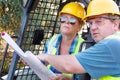 Male and Female Workers With Technical Blueprints Talking Royalty Free Stock Photo