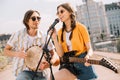 Male and female young people with guitar and djembe performing Royalty Free Stock Photo