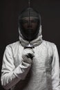 Male fencer in white fencing costume and mask