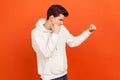 Male fighter in hoodie holding clenched fists up, ready to attack. Young man defending from bullies. Martial art school lessons