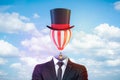 Male figure in smart suit, tie and tophat with a striped hot-air balloon instead of the head against blue sky with white