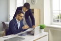 Male financial director giving directions to his assistant while working on financial report. Royalty Free Stock Photo