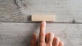 Male finger pointing to a blank simple wooden peg