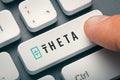 Finger pressing computer key with theta token logo