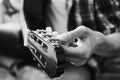 Male fingers tuning guitar strings. Black and white concept. Close-up Royalty Free Stock Photo