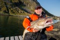 Male fisherman holding a huge fish Cod Royalty Free Stock Photo