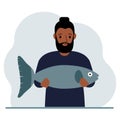 A male fisherman holds a large fish, proud of good fishing or hunting. Hobby, fishing concept. Royalty Free Stock Photo