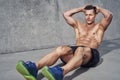 Male fitness model doing sit ups and crunches exercising abdominal muscles