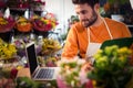 Male florist checking order in laptop