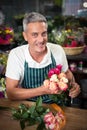 Male florist holding bunch of flowers at flower shop Royalty Free Stock Photo