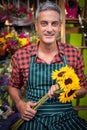 Male florist holding bunch of flowers at flower shop Royalty Free Stock Photo