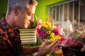 Male florist smelling flower