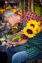 Male florist trimming stems of flowers at flower shop Royalty Free Stock Photo