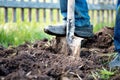 Male foot in rubber boots digging the ground in the garden bed with an old shovel in the summer garden Royalty Free Stock Photo