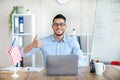 Male foreign languages tutor teaching English online on laptop, showing thumb up gesture at home Royalty Free Stock Photo