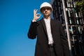 male foreman at a construction site shows ok, like, cool job, Architectural engineering holds a laptop at a construction site,