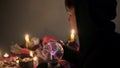 Male fortune teller performing ritual with crystal ball foreseeing future