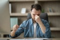 Male Freelancer Suffering Eyes Strain, Taking Off Glasses And Massaging Nose Bridge