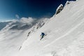 Male freerider skis sideways down on snowy mountain slope