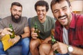 Male friends drinking beer while spending leisure time at home Royalty Free Stock Photo