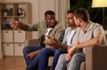 Male friends watching tv and talking at home Royalty Free Stock Photo