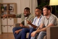 Male friends watching tv and talking at home Royalty Free Stock Photo