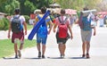 Male friendship concept. Four young guys with travel backpacks go on touristic place. Hike in summer day.