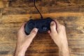 Male gamer using gamepad controller on wooden desk, top view Royalty Free Stock Photo