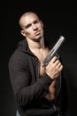 Male gangster holding a gun isolated on black