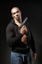 Male gangster holding a gun isolated on dark