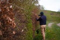 A male gardener trims a hedge in early spring, leveling it with stretched laces