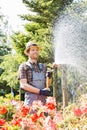 Male gardener watering plants at plant nursery