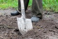 Male gardener worker digging in vegetable garden with shovel. Farmer man in rubber boots working hands with spade dig Royalty Free Stock Photo