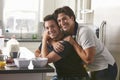 Male gay couple embracing in their kitchen, side view Royalty Free Stock Photo