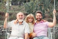 Male generation family together with three different generations ages grandfather father and son having fun on a swing Royalty Free Stock Photo